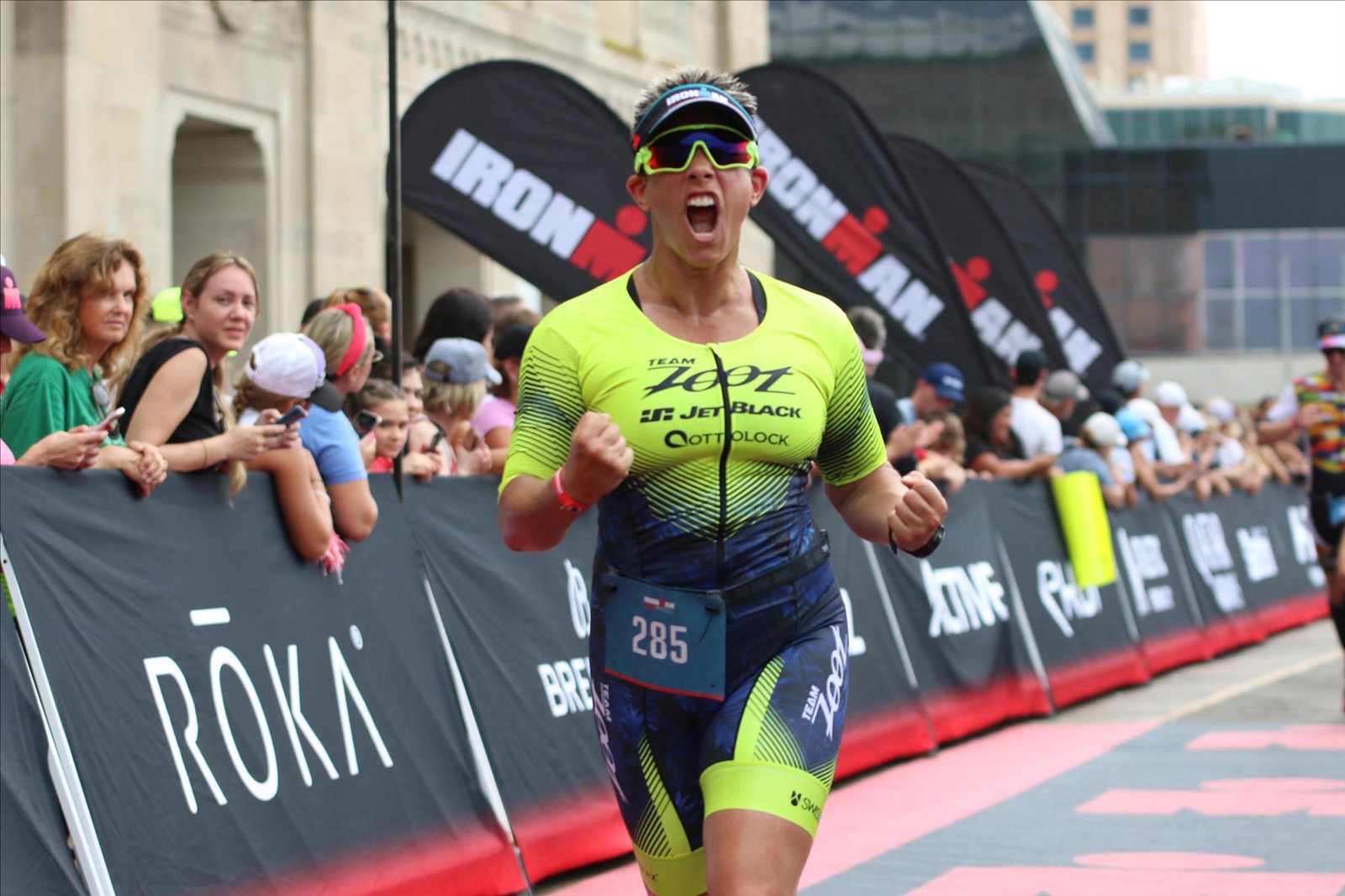 Triathlete celebrating as she reaches the Ironman finish line